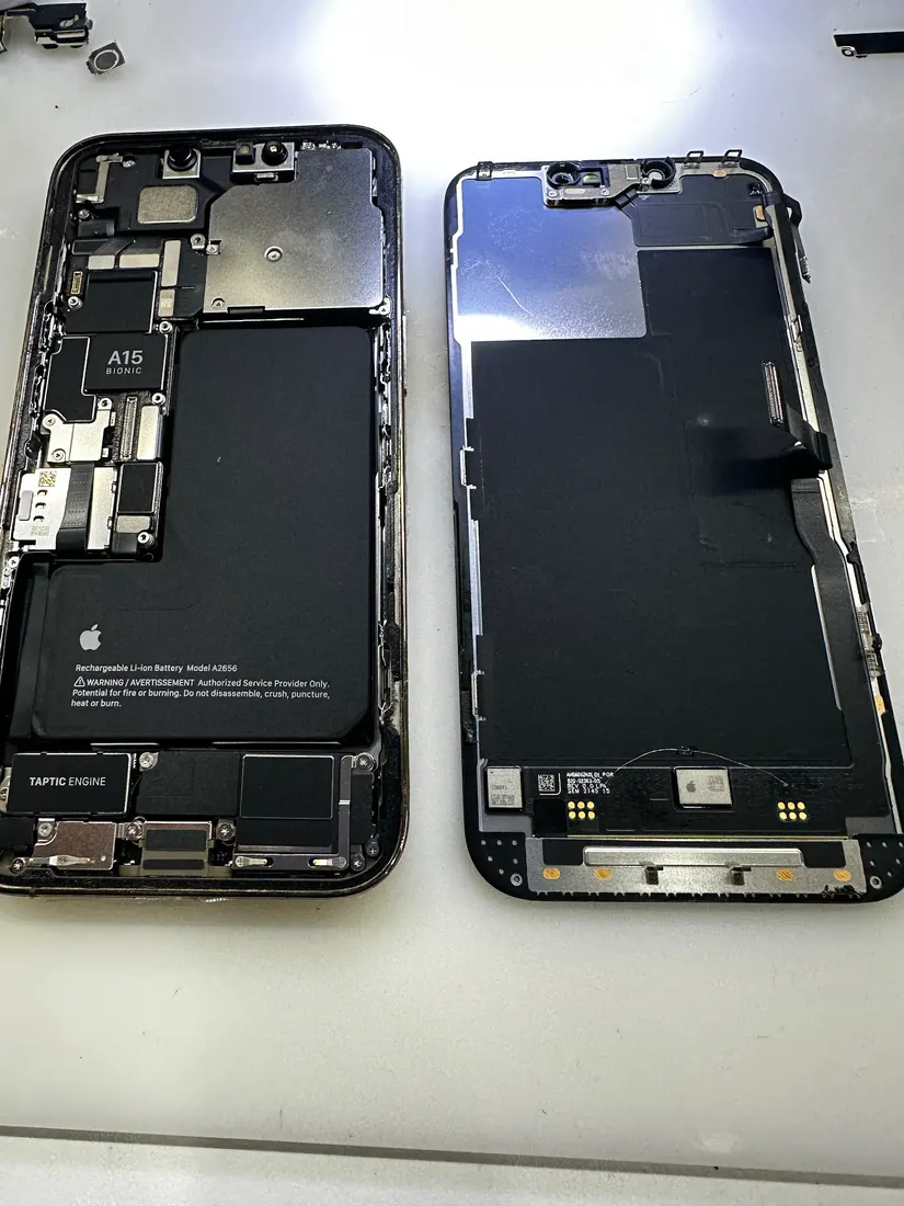兩支拆解開的 iPhone 13 Pro 機身並排,螢幕已與機身分離
