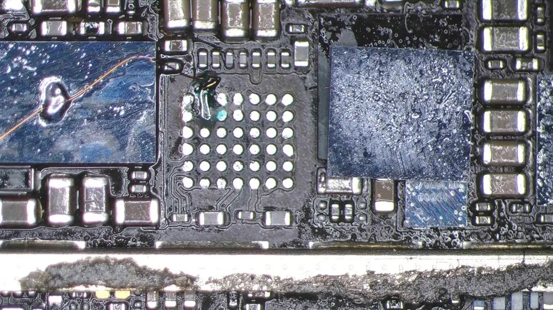 iPhone 8 Plus 主機板另一區域的腐蝕範圍，元件周圍可見結晶