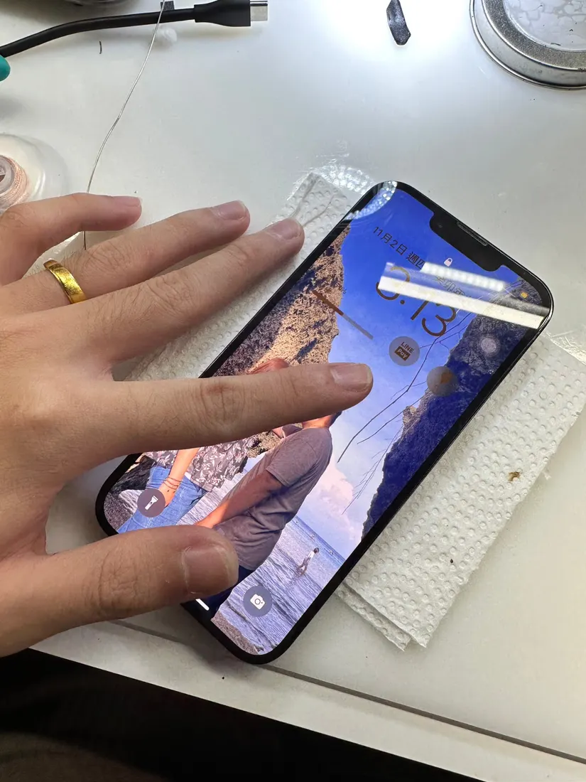 修復完成的 iPhone 13 Pro 開機顯示畫面,手持測試中