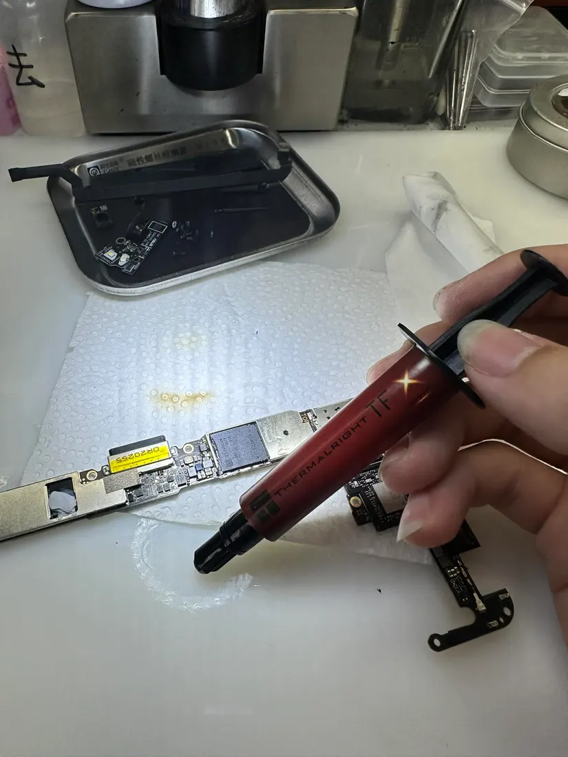 維修人員手持散熱膏針筒，準備為 ROG Phone 3 處理器塗佈散熱膏