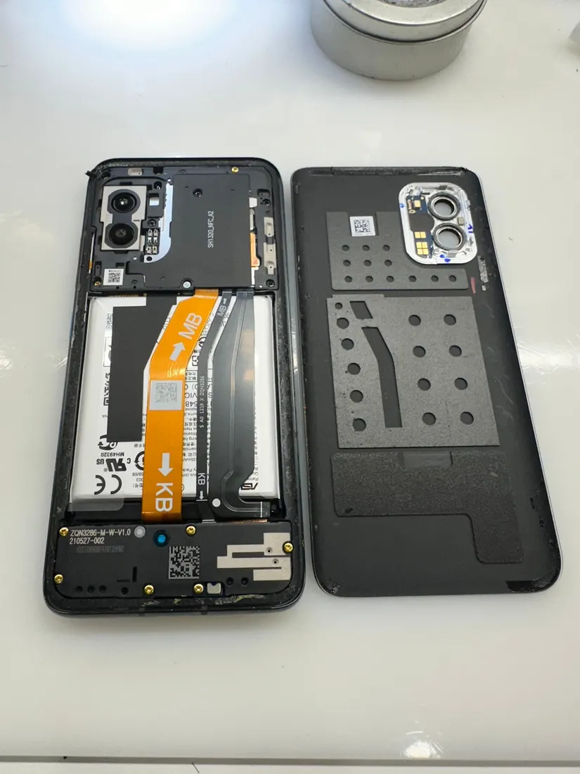拆開的 ASUS Zenfone 8，可見內部電池與拆下的背蓋