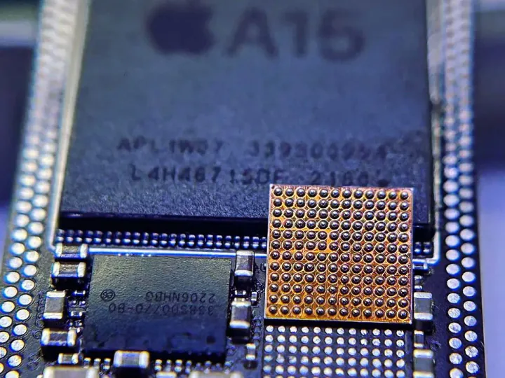iPhone 主機板上的 A15 晶片與重新植球的電源 IC 微距照